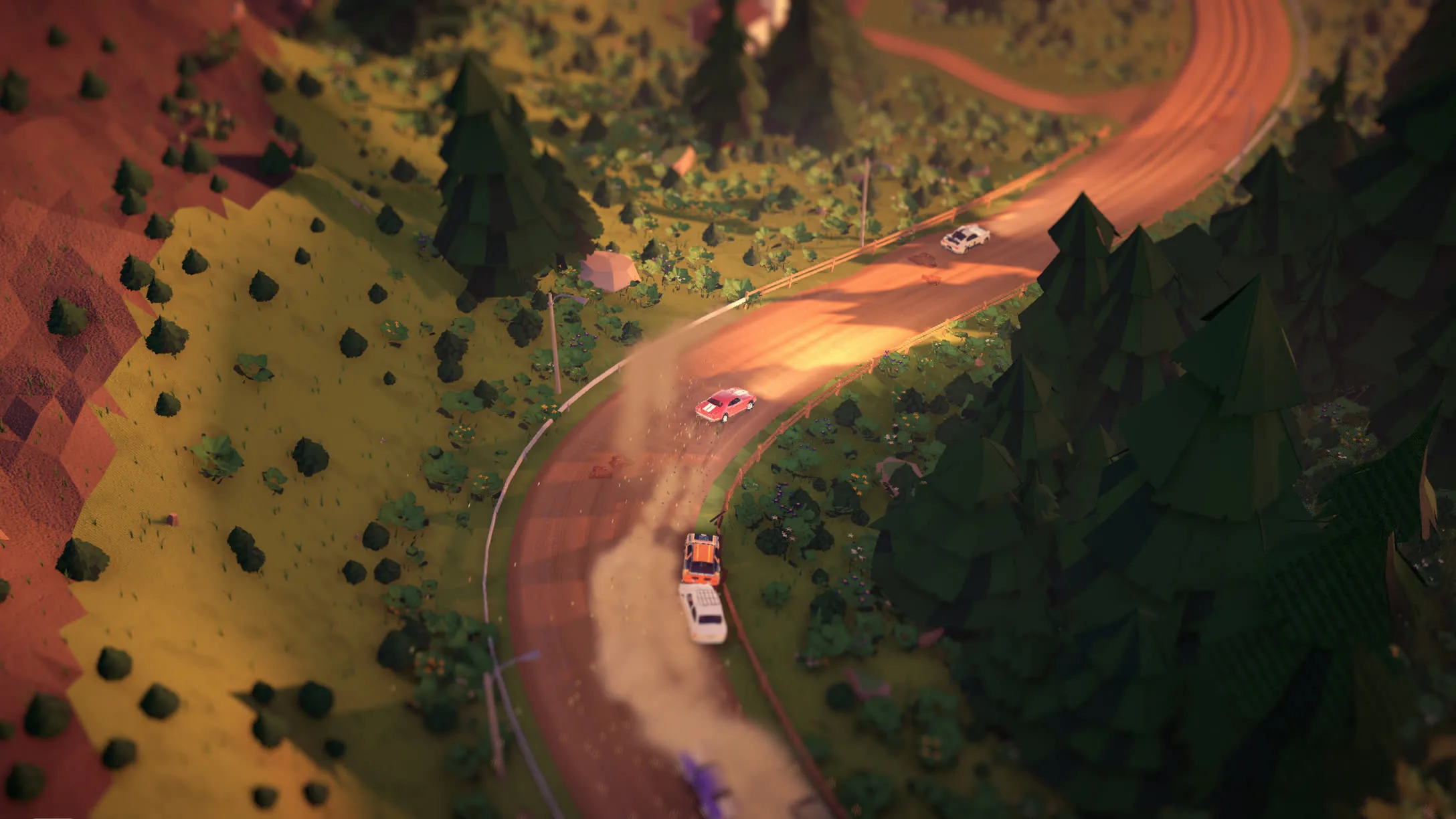 A gravel road snaking through pine hills at dusk, a pack of cars sliding along it