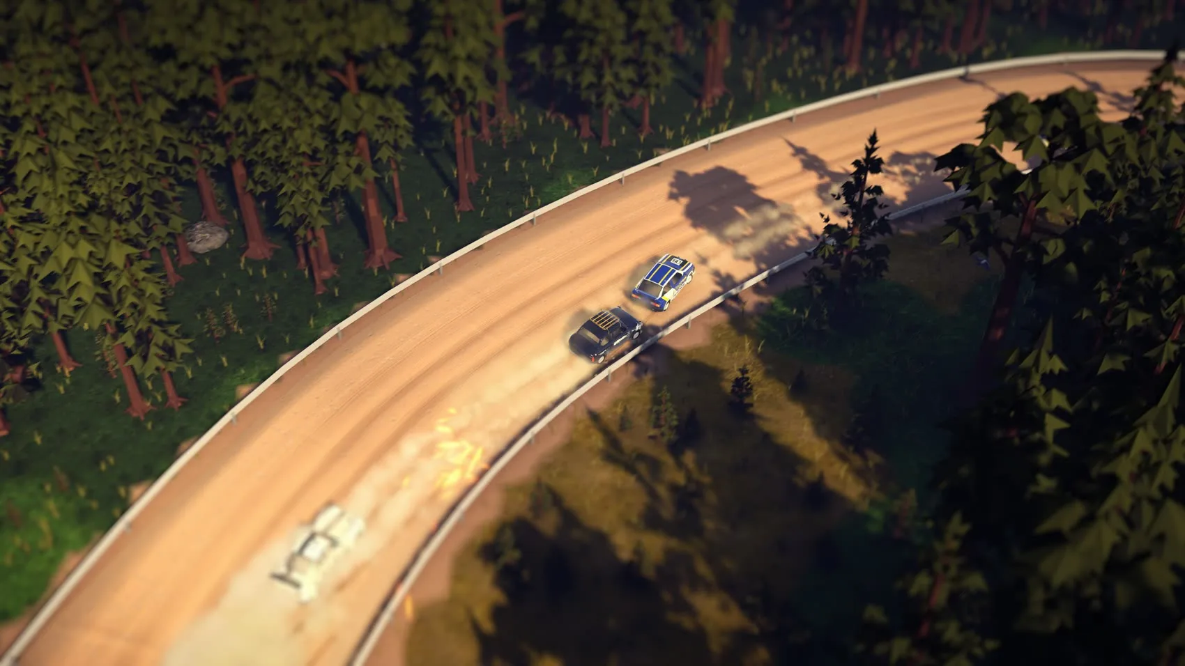 High over a forest: a gravel road with guardrails curving through the pines, the field strung along it