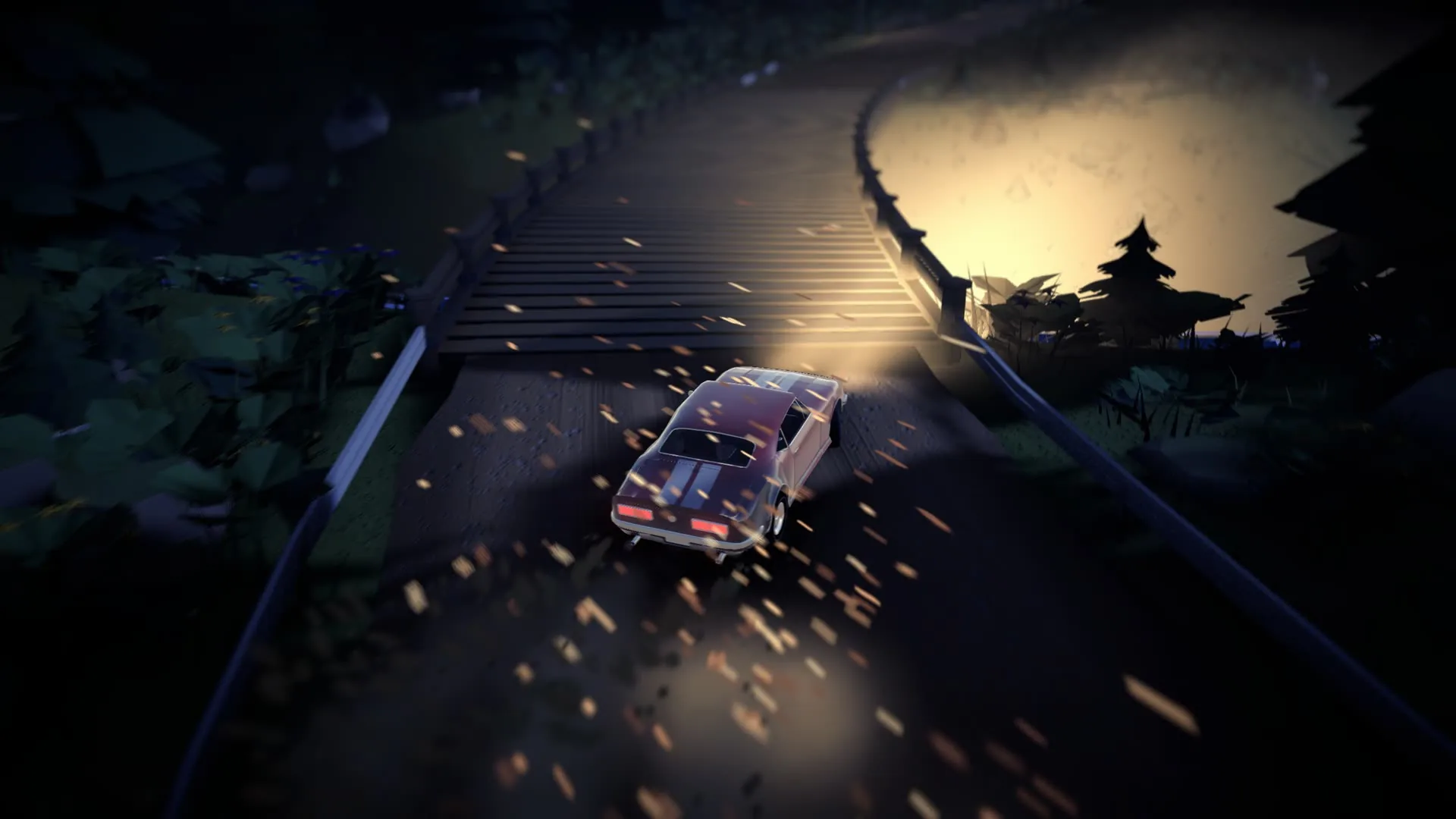 Night: a car drifting in its own headlights, gravel flying